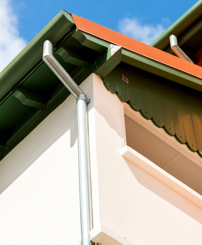 Travaux de zinguerie sur une descente pluviale en zinc